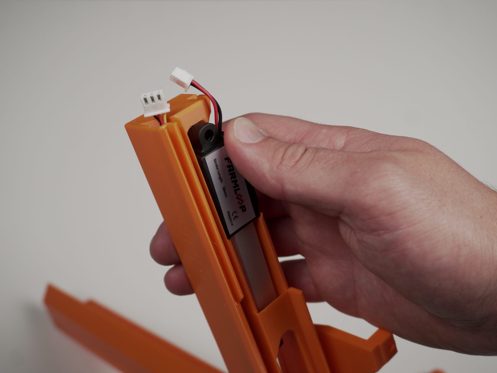 FarmLoop 50 mm actuator held in hand, with its cable connectors