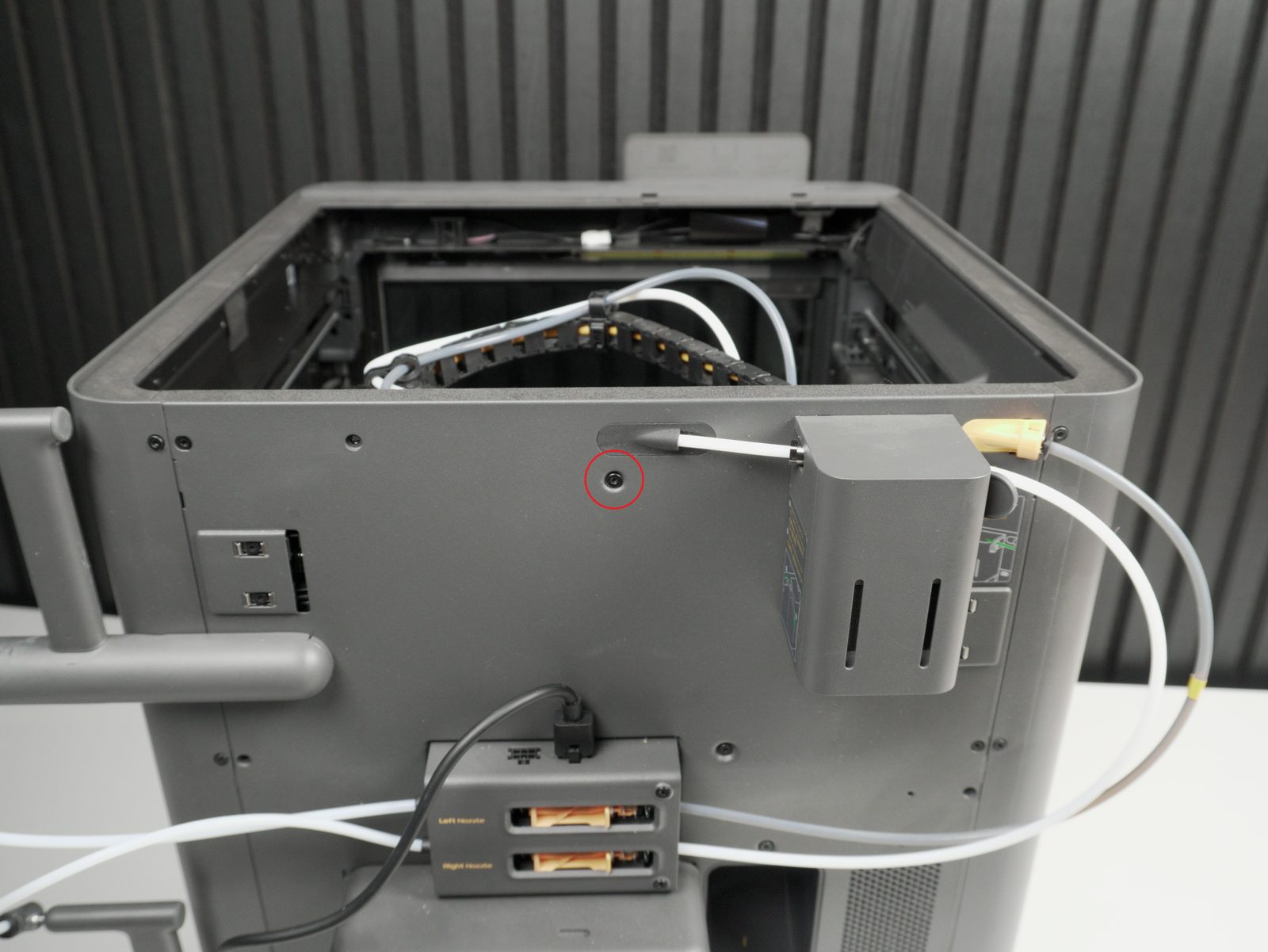 Marked screw location on the back of the printer for mounting the PCB basket, circled in red