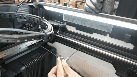 Side panel loosened, wire harness guide slid into the gap, harness routed through the guide