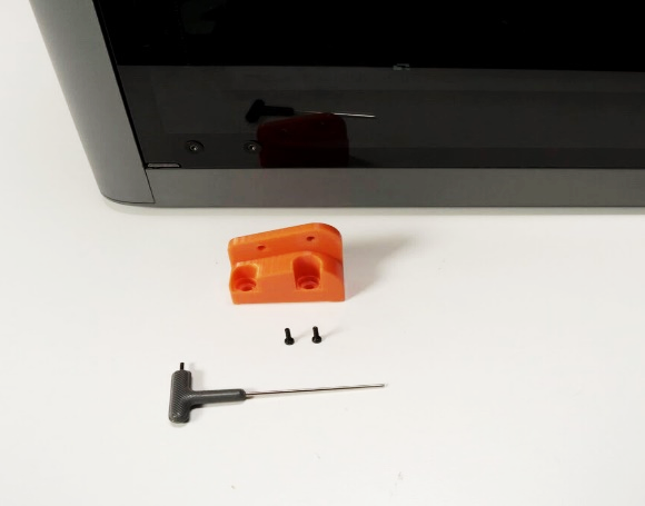 Parts laid out: orange bracket, two screws, screwdriver