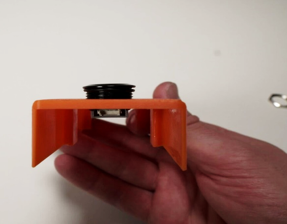 Pressing the button into the designated hole in the lid